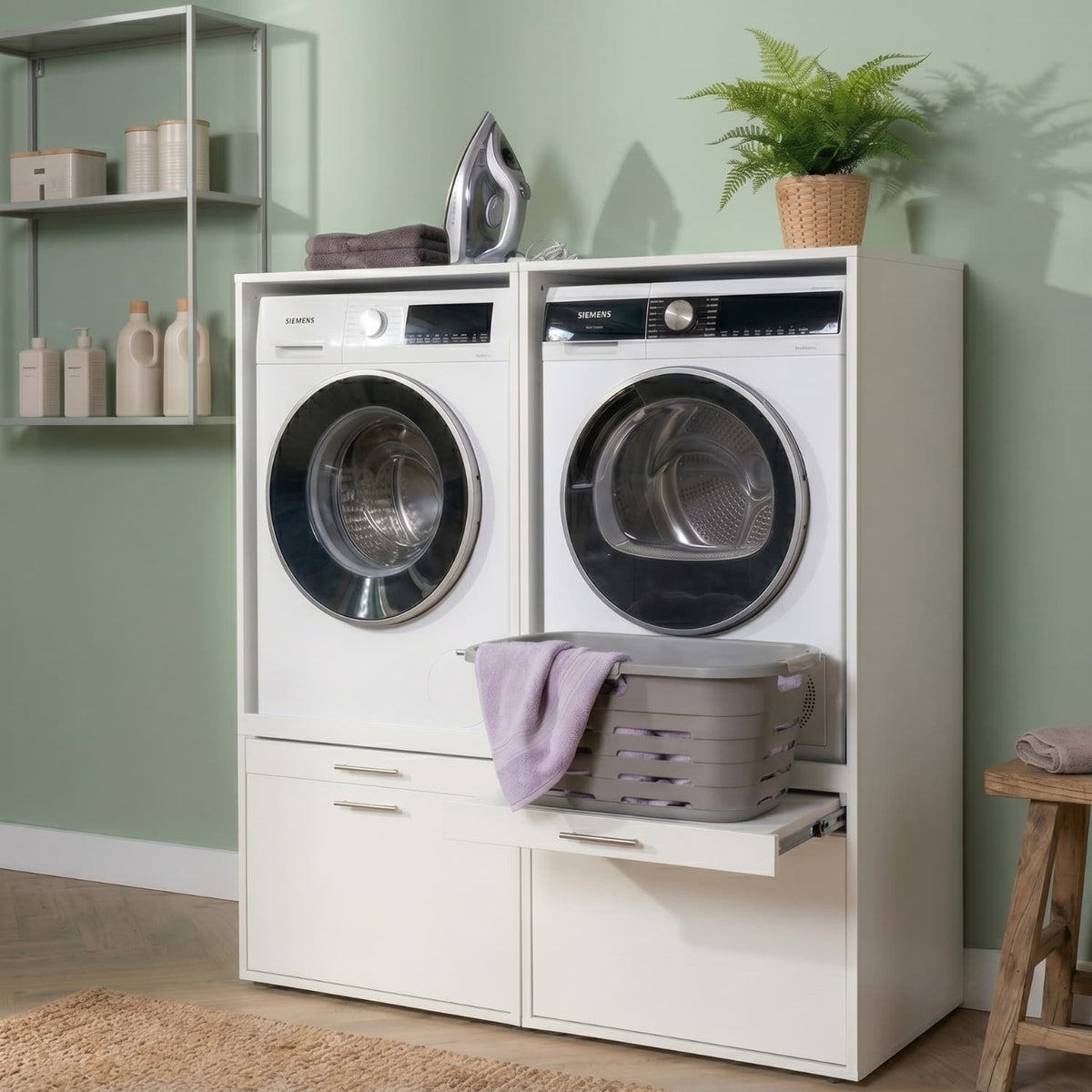 White stacked washer and dryer duo set with front-loading doors, laundry basket, and lavender towel on pull-out shelf.